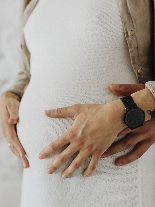 Schwangere Frau mit ihrem Partner im Wohnzimmer