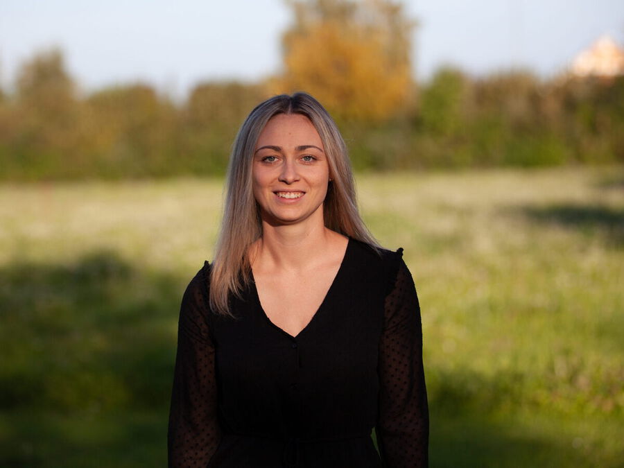 Sarah im Freien vor einer Wiese